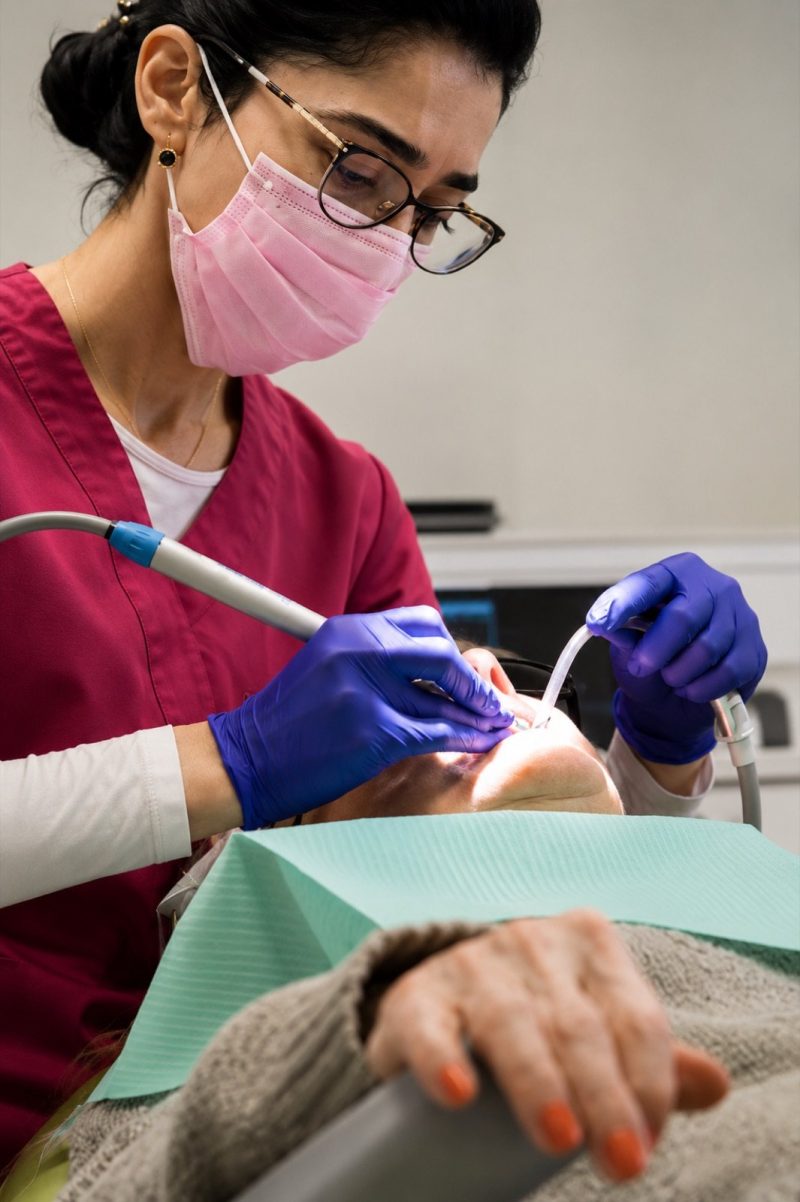 Dental hygienist cleaning a patient's teeth at Genesis Dental Centre